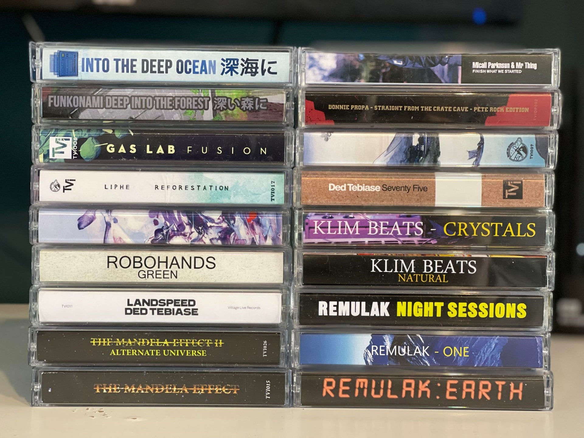 A neatly stacked collection of Village Live Records cassette tape releases, featuring albums from Funkonami, Robohands, Klim Beats, Ded Tebiase, Remulak, and more.