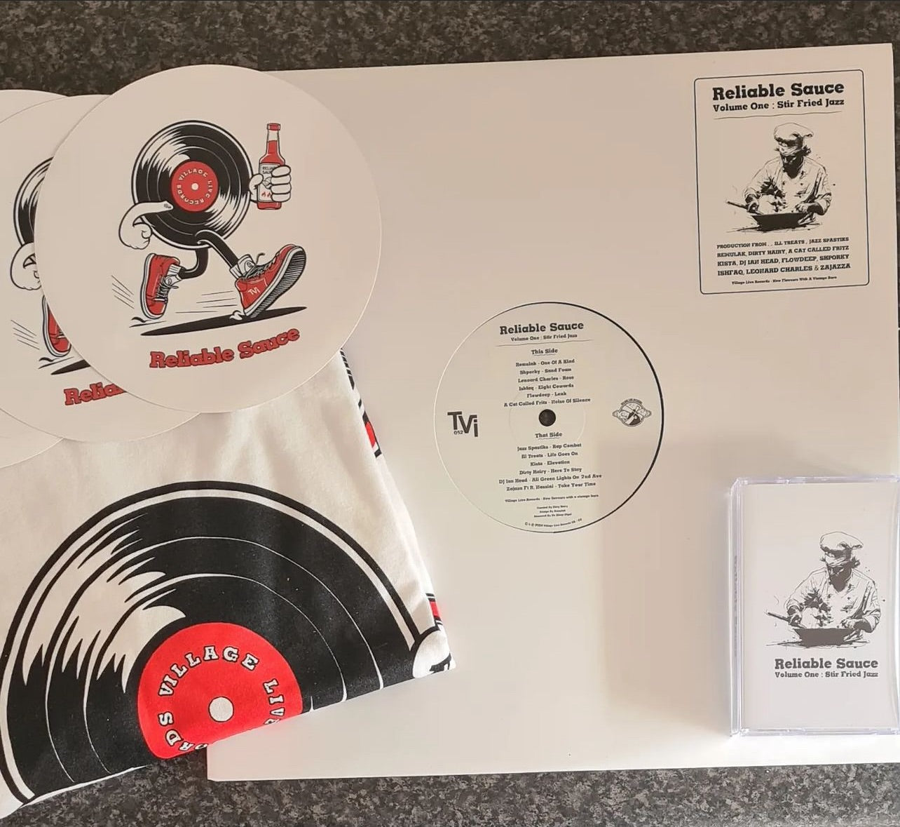 Reliable Sauce Volume One merch bundle displayed on a table, including a vinyl record, cassette tape, T-shirt, sticker pack, and album cover artwork.